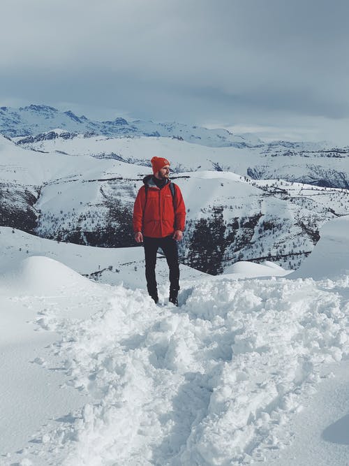 穿红色夹克的人站立在积雪的地面上 · 免费素材图片