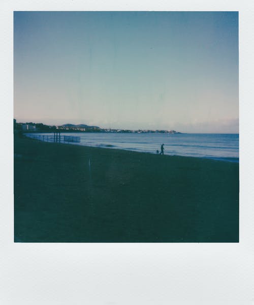 在沙滩线上行走的人 · 免费素材图片