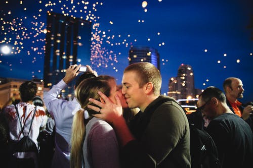 夫妇在人群附近接吻的照片 · 免费素材图片