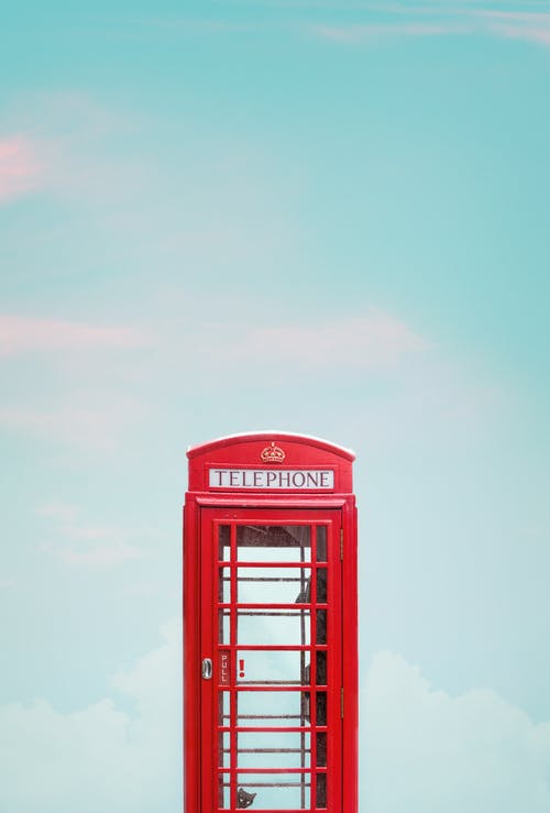 蓝蓝的天空下的红色电话亭的照片 · 免费素材图片