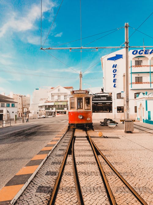 蓝天白云下的海洋酒店附近的红色和白色电车 · 免费素材图片