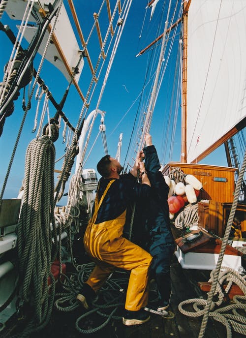 两名男子拿着帆船的绳索 · 免费素材图片