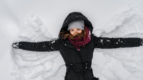 黑色外套和灰色针织帽在雪地上的女人 · 免费素材图片