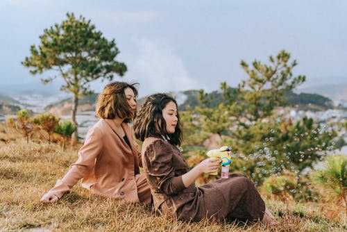 两个女人坐在地上 · 免费素材图片