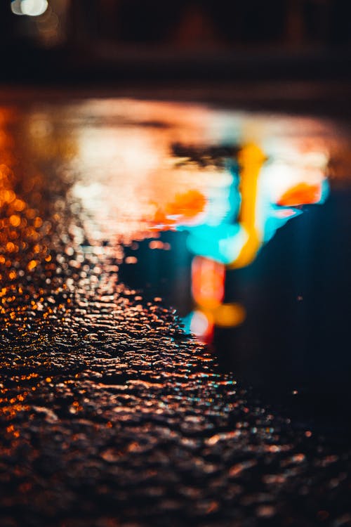 夜间黑沥青路面上的水滴 · 免费素材图片