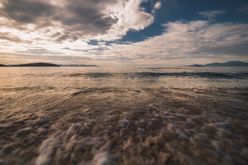 海浪在日落期间在海岸上崩溃 · 免费素材图片