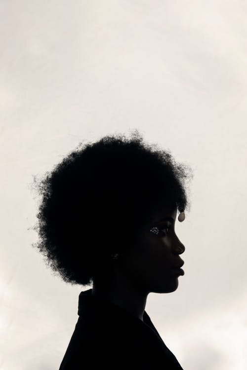 具有超凡魅力的年轻非洲裔美国女士，多云的天空 · 免费素材图片