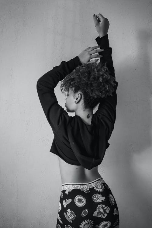 女人站在墙附近的单色照片 · 免费素材图片