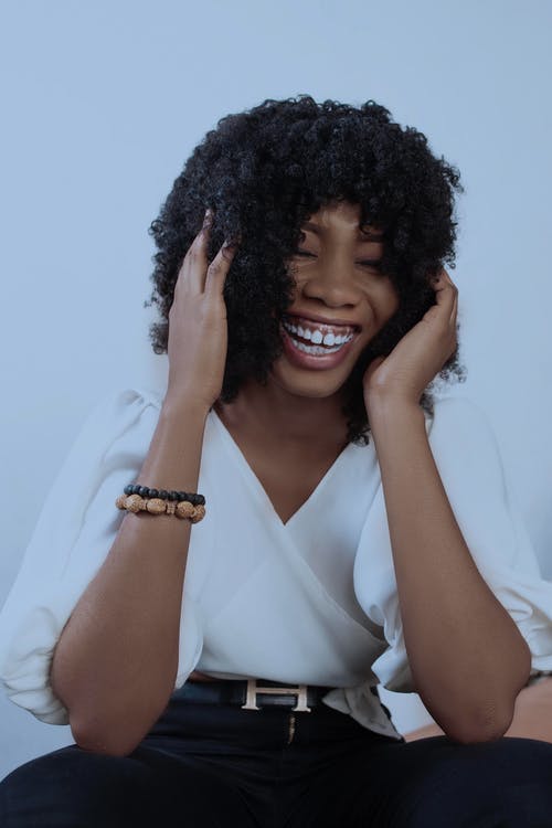 卷曲的头发，开心地笑着的黑女人 · 免费素材图片