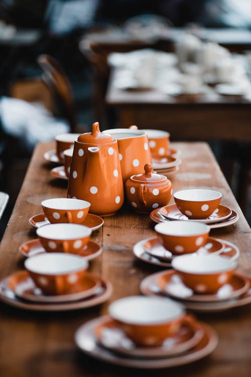 橙色和白色陶瓷茶杯棕色木制的桌子上 · 免费素材图片