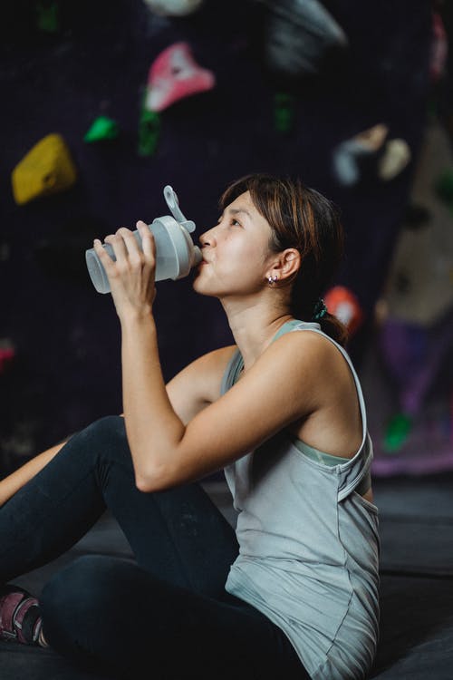 抱石锻炼后渴族裔女运动员饮用水 · 免费素材图片