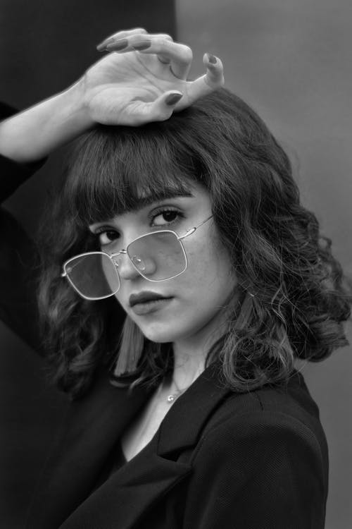 女人把她的手放在她的头上的灰度摄影 · 免费素材图片