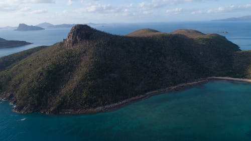 高绿色的山和海洋在多云的天空下 · 免费素材图片