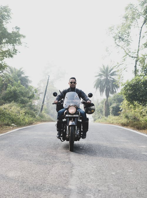 男子骑摩托车在路上 · 免费素材图片