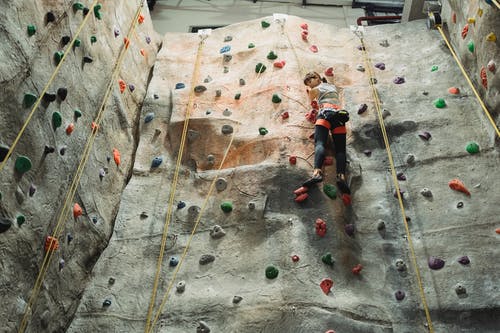 亚洲登山者在锻炼期间上升攀岩墙 · 免费素材图片