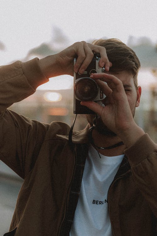 无法识别的摄影师在大街上的复古相机上拍照 · 免费素材图片