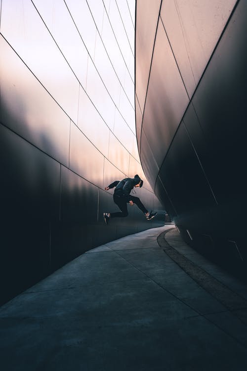 男子在人行道上跳跃的照片 · 免费素材图片