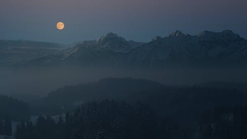 满月下的薄雾笼罩的山脉的轮廓 · 免费素材图片