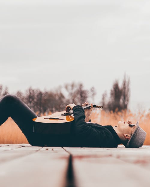 吉他躺在码头上的男人 · 免费素材图片