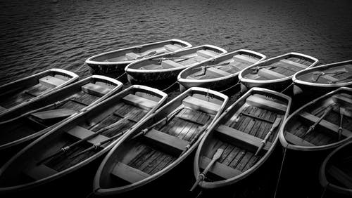 木制划艇在水体上的灰度摄影 · 免费素材图片