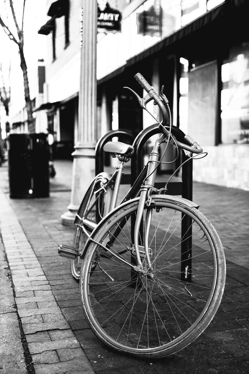 停在人行道上的自行车的灰度照片 · 免费素材图片
