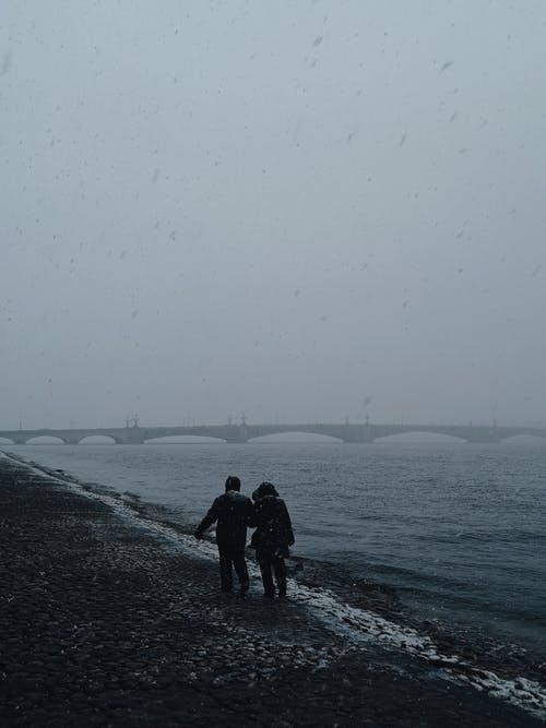 两人在海边散步的摄影 · 免费素材图片