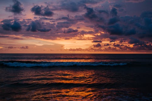 日落时海浪上空的云 · 免费素材图片