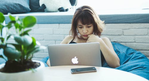 黑色背心的女人使用银色macbook · 免费素材图片