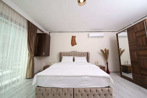 白色床单和棕色床架 · 免费素材图片