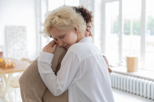 多种族的女人在房间里温柔地拥抱 · 免费素材图片