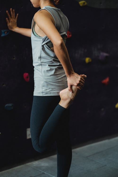 坚强的年轻女子，在攀爬训练前伸展腿 · 免费素材图片