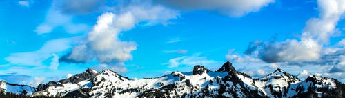 蓝多云的天空下的白色和黑色雪山 · 免费素材图片