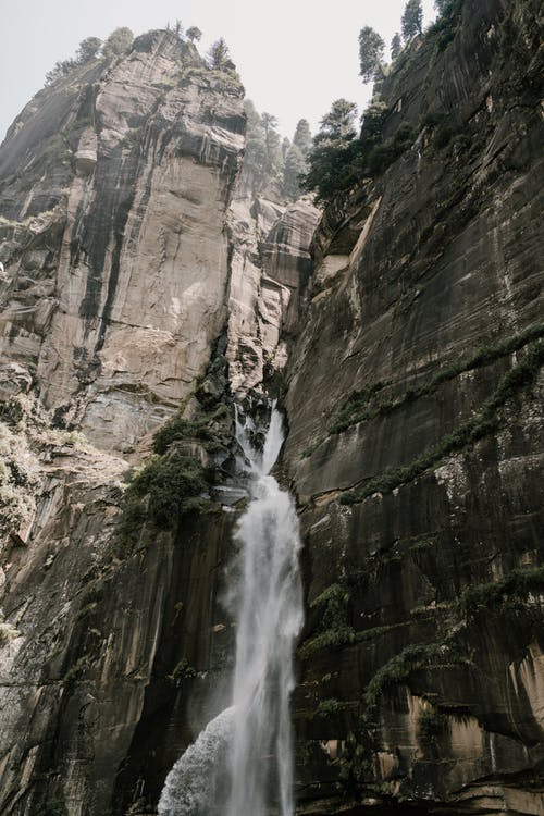 快速瀑布流过野生山谷的岩石峭壁 · 免费素材图片