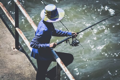 蓝色长袖衬衫和黑色的裤子，用钓鱼竿的人 · 免费素材图片