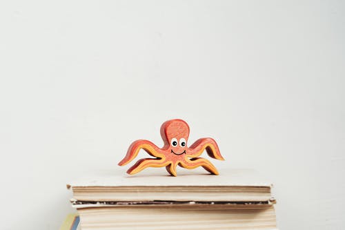 木制章鱼小雕像上书 · 免费素材图片