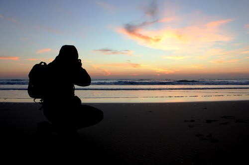 在海洋附近拍照的人的剪影 · 免费素材图片