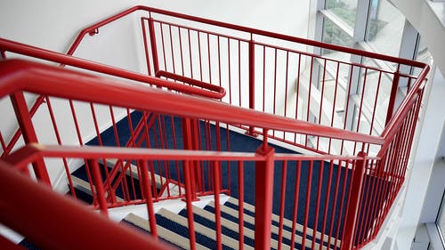 红色金属扶手的蓝色和白色木制楼梯 · 免费素材图片