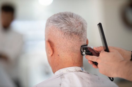 在人的头发上使用剃刀的人 · 免费素材图片