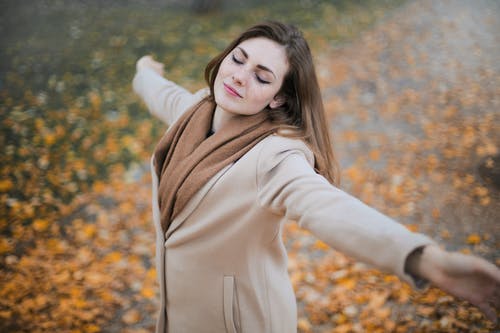 米色的长袖外套站在棕色的叶子上的女人 · 免费素材图片