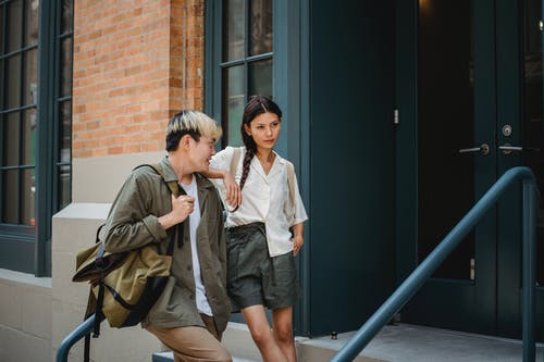 时髦的亚洲夫妇站在现代建筑的入口附近 · 免费素材图片