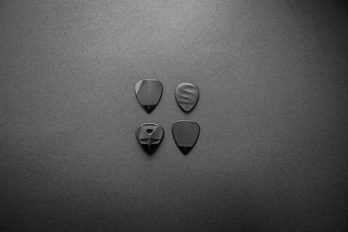 四个吉他拨片的灰度摄影 · 免费素材图片