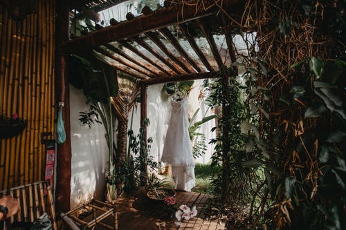 白色礼服挂在花园附近 · 免费素材图片