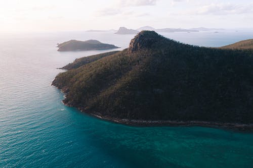 在多云的天空下的涟漪海附近的绿化山 · 免费素材图片