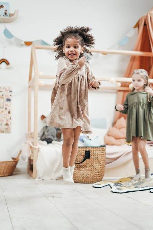 跳跃时穿棕色衣服的女孩 · 免费素材图片
