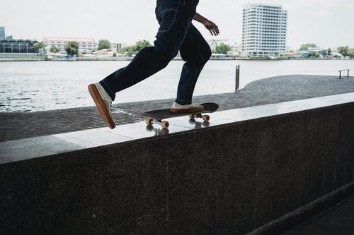 作物人骑在堤岸上的滑板 · 免费素材图片
