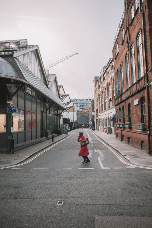 过马路的红色风衣的女人 · 免费素材图片