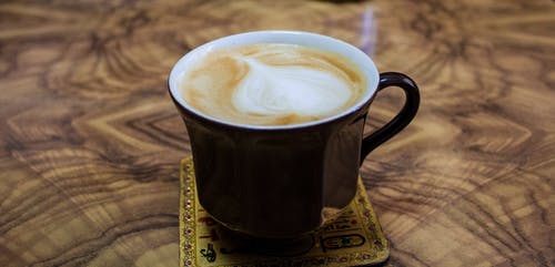 黑色陶瓷杯上的卡布奇诺咖啡 · 免费素材图片