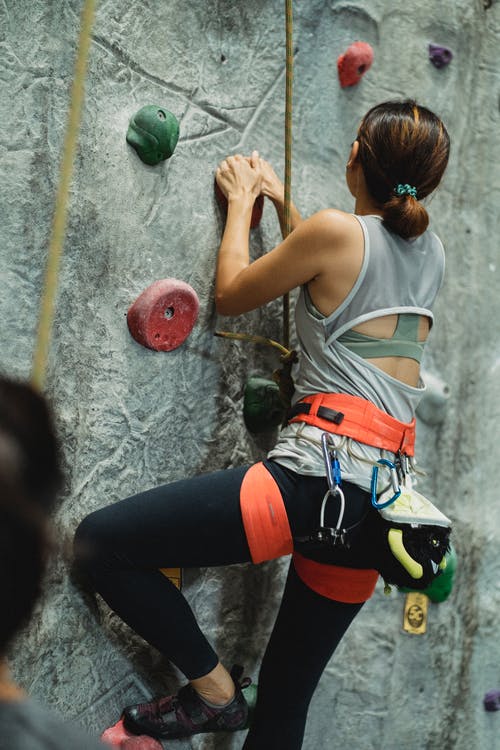庄稼教练附近无法辨认的坚强女性登山攀岩墙 · 免费素材图片