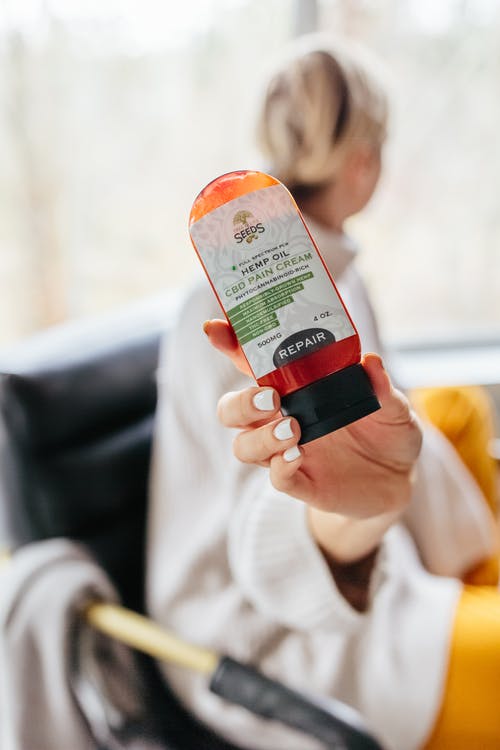 拿着橙色塑料瓶的人 · 免费素材图片