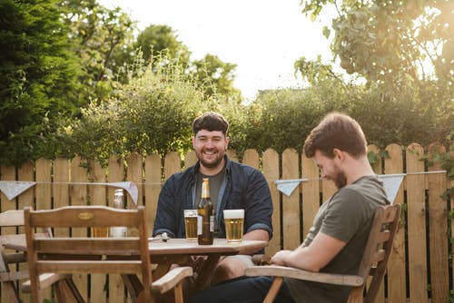 性格开朗的人在后院聊天，喝啤酒 · 免费素材图片